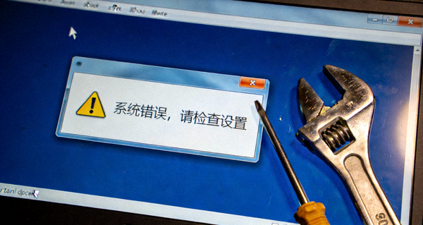 电脑屏幕上显示一个带有感叹号的错误弹窗，旁边有一把螺丝刀和扳手，象征着故障排查与修复